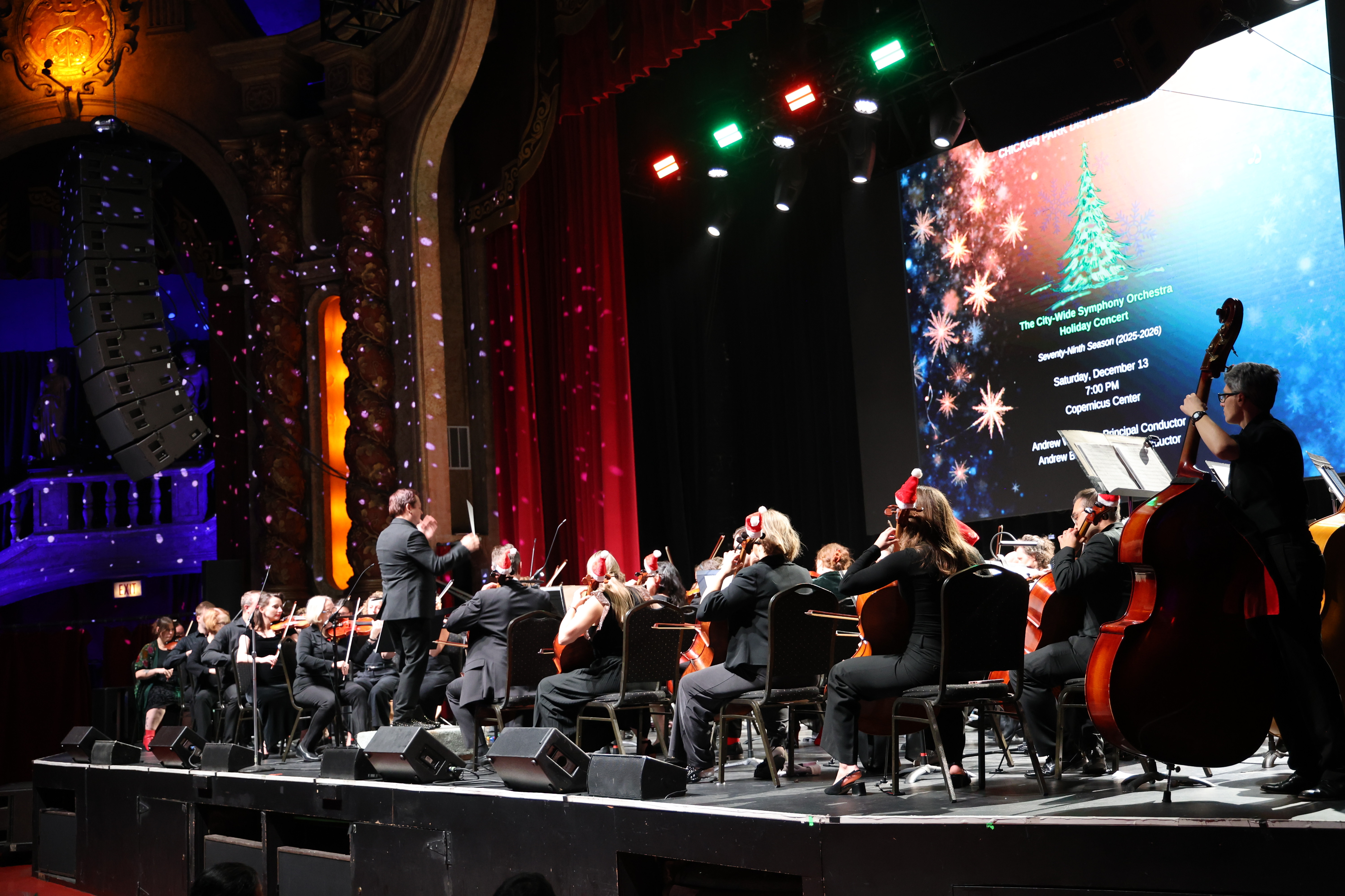 Orchestra performing a holiday concert on stage.